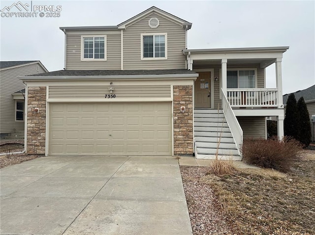 view of front of home with a garage, concrete driveway, and stone siding