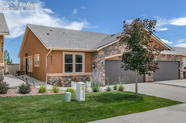 view of front of property featuring an attached garage, a shingled roof, stone siding, concrete driveway, and a front lawn