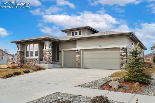 prairie-style home with stone siding, an attached garage, and concrete driveway