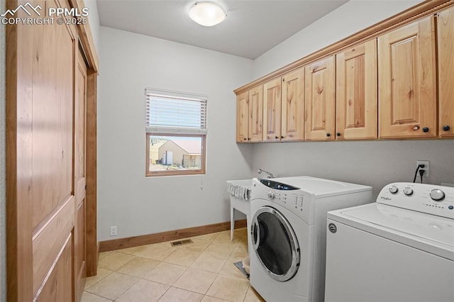 washroom with light tile patterned floors, cabinet space, visible vents, washer and dryer, and baseboards