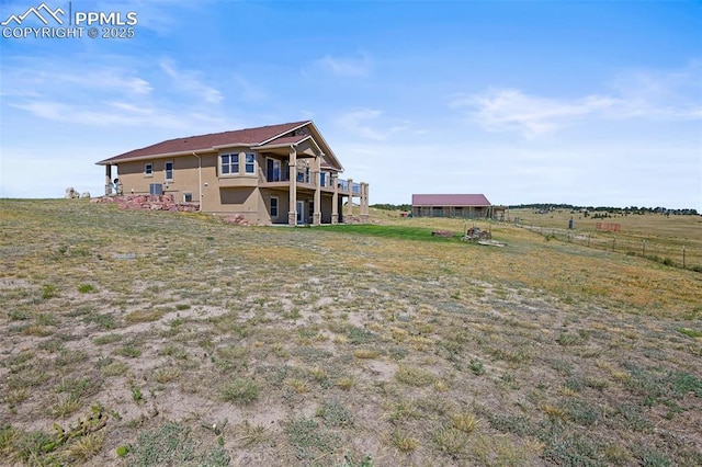 rear view of property featuring fence and a lawn