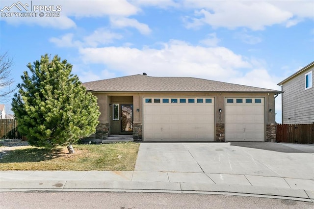 view of front of house featuring stucco siding, stone siding, concrete driveway, and fence