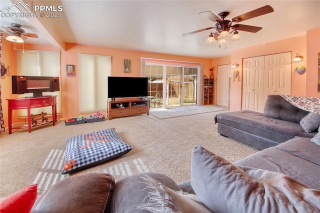 carpeted living area with a ceiling fan