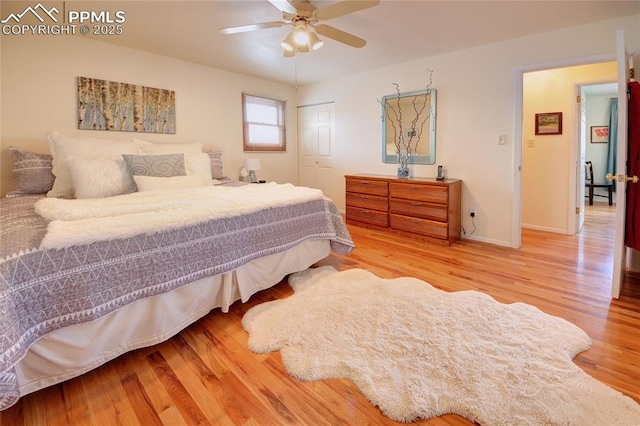 bedroom with ceiling fan, a closet, wood finished floors, and baseboards