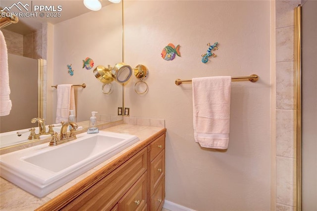 bathroom featuring a shower with door and vanity