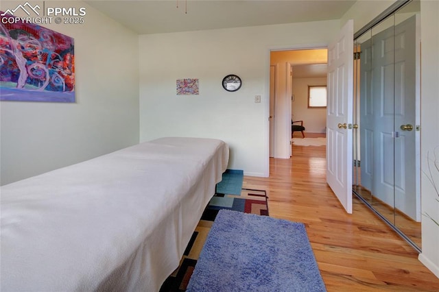 bedroom with a closet, baseboards, and wood finished floors