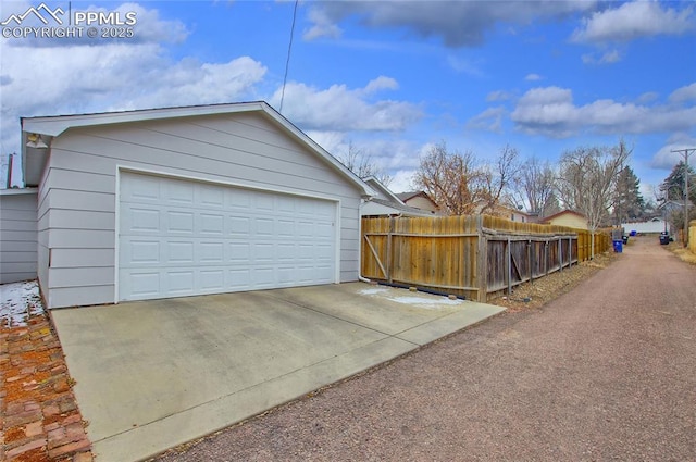 detached garage featuring fence