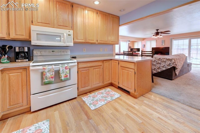 kitchen featuring open floor plan, light countertops, white appliances, and plenty of natural light