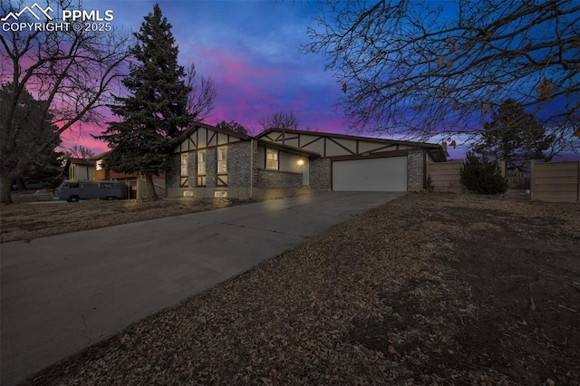 view of front of property with concrete driveway, stucco siding, brick siding, and a garage