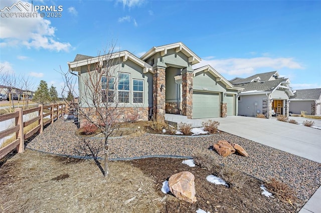 view of front facade featuring an attached garage, fence, stone siding, driveway, and stucco siding