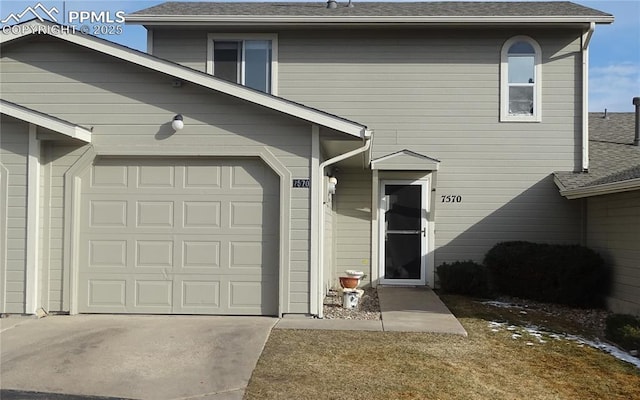 view of front of property with roof with shingles and driveway