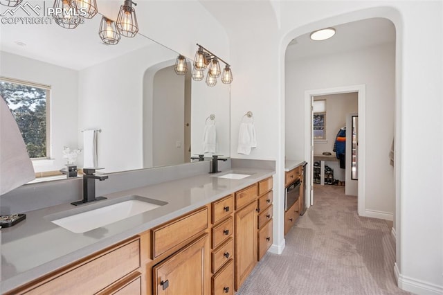 bathroom featuring a sink, baseboards, and double vanity