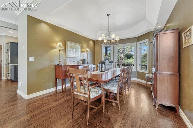 dining area with a textured wall, baseboards, dark wood finished floors, and a raised ceiling