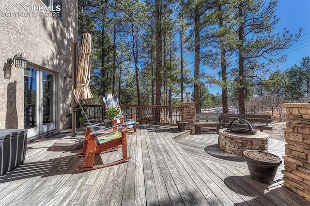 wooden terrace featuring a fire pit and central air condition unit