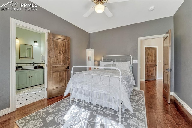 bedroom with lofted ceiling, ensuite bathroom, a ceiling fan, wood finished floors, and baseboards