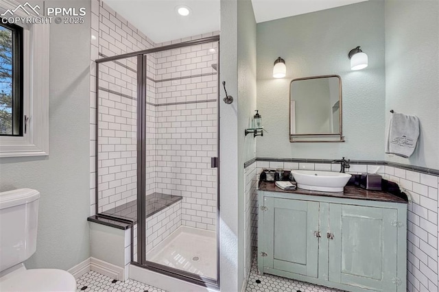 full bathroom with toilet, a shower stall, tile walls, and tile patterned flooring