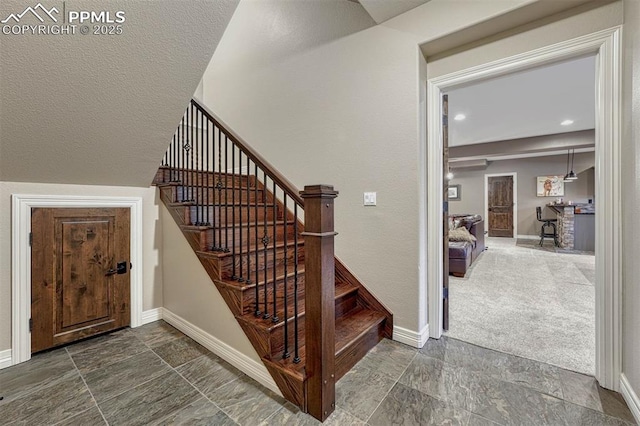 staircase with stone finish floor, baseboards, and recessed lighting