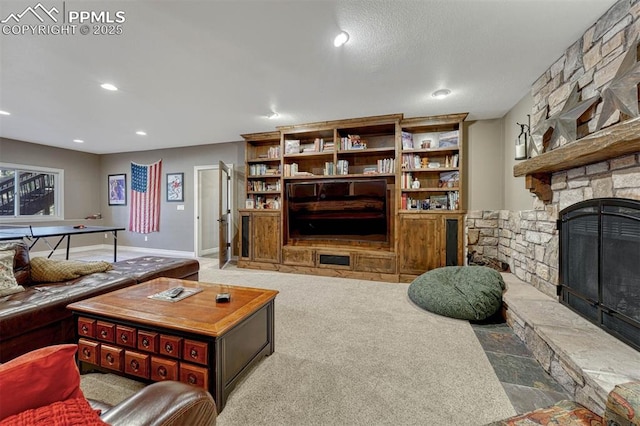 living room with recessed lighting, a stone fireplace, and baseboards