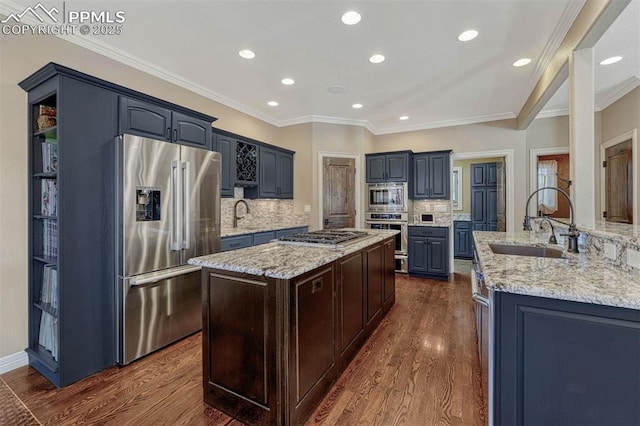 kitchen featuring dark wood-style floors, appliances with stainless steel finishes, a sink, and a center island