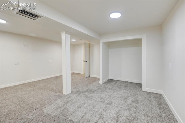 finished below grade area with light colored carpet, visible vents, and baseboards