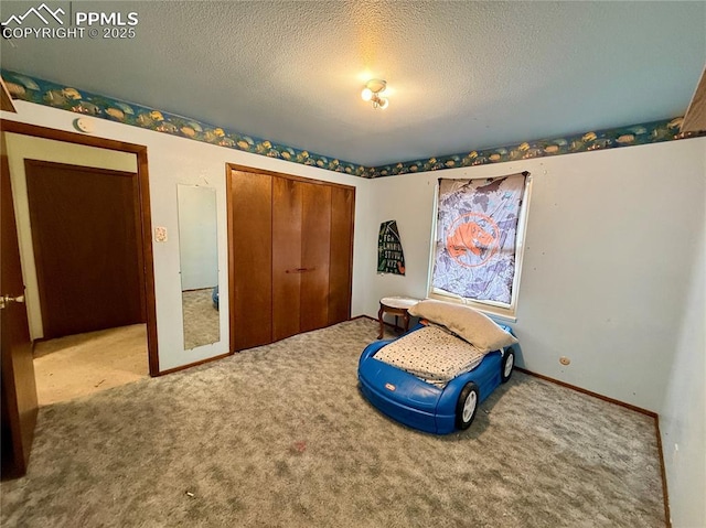 bedroom featuring a closet, carpet flooring, a textured ceiling, and baseboards