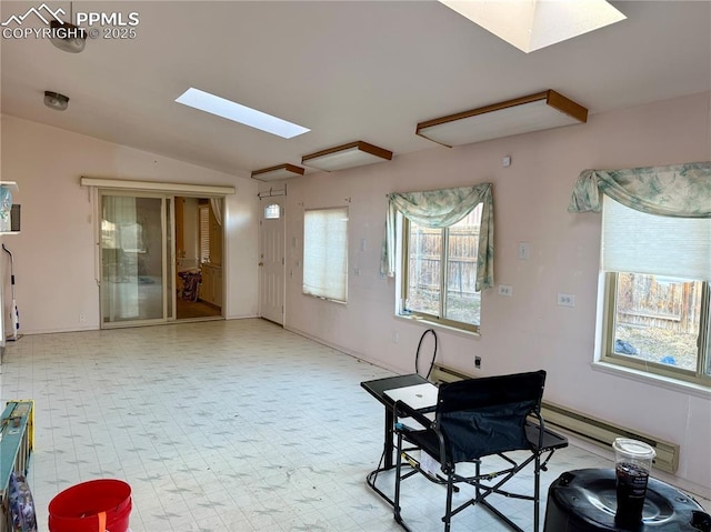 interior space with vaulted ceiling with skylight, baseboard heating, plenty of natural light, and tile patterned floors