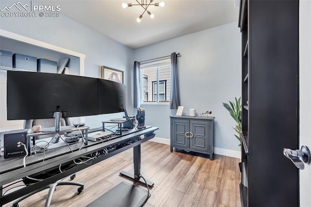 office area featuring baseboards, an inviting chandelier, and light wood-style floors