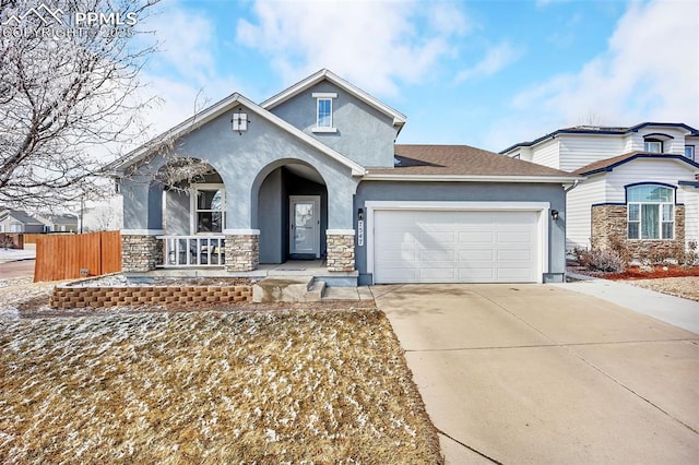 view of front of property featuring concrete driveway, fence, an attached garage, and stucco siding