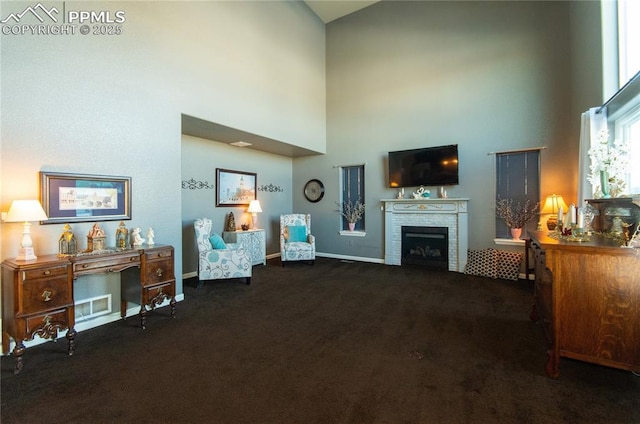 living room with baseboards, visible vents, a towering ceiling, dark colored carpet, and a fireplace