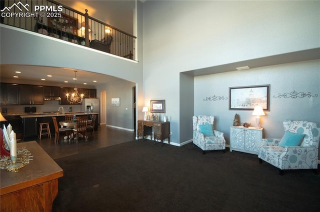 living area featuring a high ceiling, dark carpet, recessed lighting, and baseboards