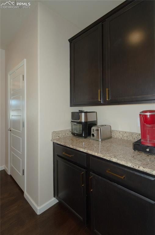 bar featuring baseboards and dark wood-type flooring