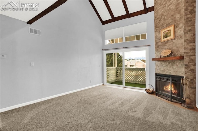 unfurnished living room featuring a large fireplace, visible vents, baseboards, beam ceiling, and carpet