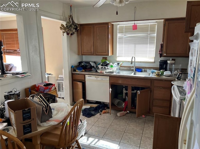 kitchen featuring a healthy amount of sunlight, white appliances, brown cabinets, and a sink