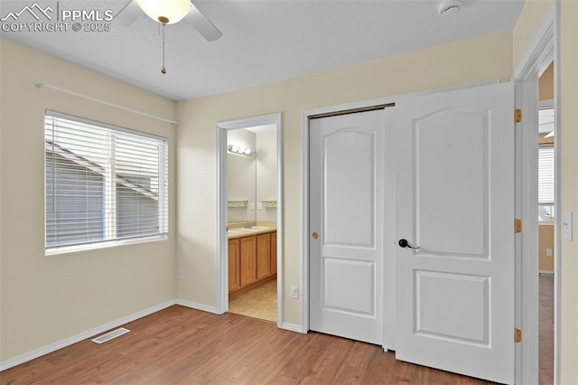 unfurnished bedroom with baseboards, visible vents, connected bathroom, light wood-style floors, and a closet