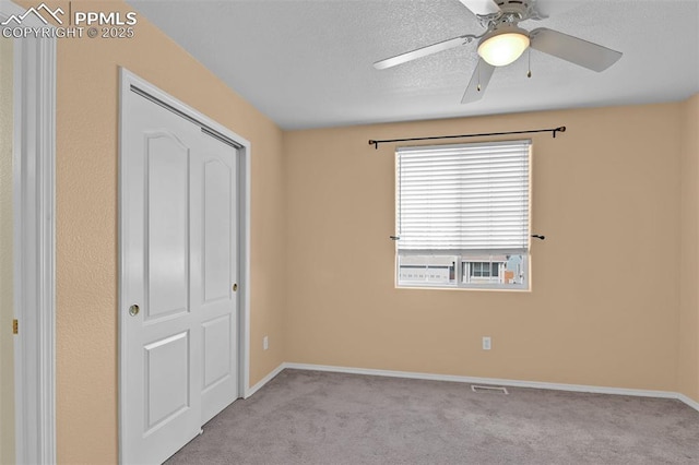 unfurnished bedroom featuring baseboards, visible vents, ceiling fan, and carpet flooring