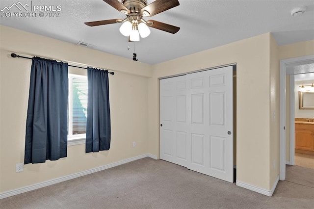 unfurnished bedroom featuring carpet floors, a closet, visible vents, ceiling fan, and baseboards