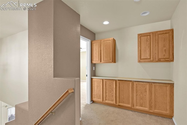 hallway featuring recessed lighting, an upstairs landing, and light colored carpet