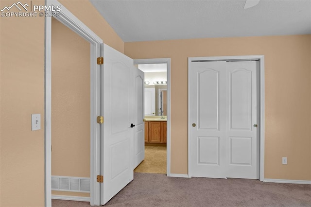 unfurnished bedroom featuring carpet, baseboards, and a closet