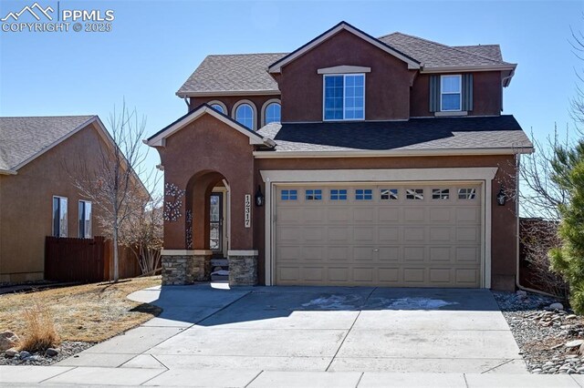 traditional-style home featuring driveway, a garage, and stucco siding