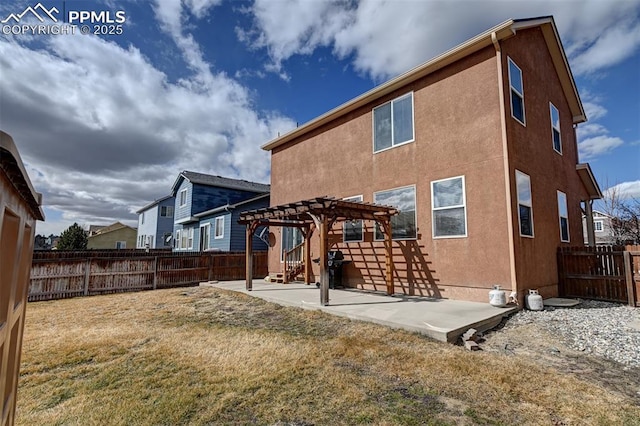 back of property with a patio, stucco siding, a fenced backyard, and a pergola