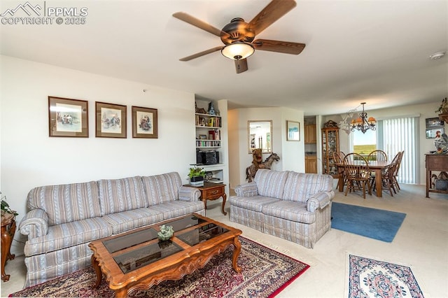 carpeted living area featuring ceiling fan with notable chandelier