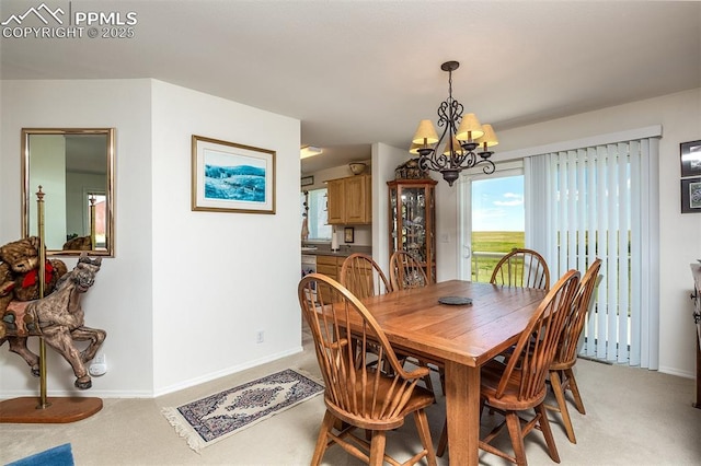 dining room featuring baseboards, a chandelier, and light colored carpet