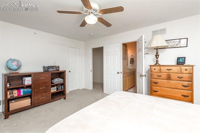 bedroom featuring ensuite bathroom, ceiling fan, visible vents, and light colored carpet