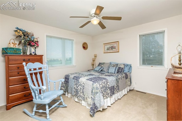 bedroom featuring visible vents, a ceiling fan, and light colored carpet