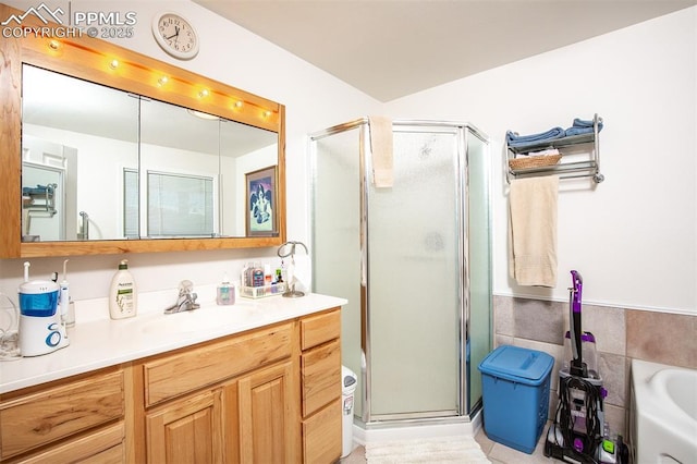 full bath with tile walls, a shower stall, vanity, and a bath