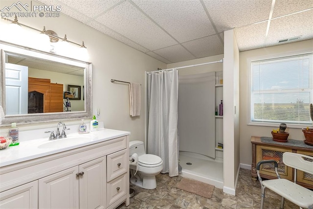 bathroom featuring a paneled ceiling, a shower stall, visible vents, and toilet