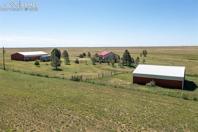 view of yard with a pole building, fence, an outdoor structure, and a rural view