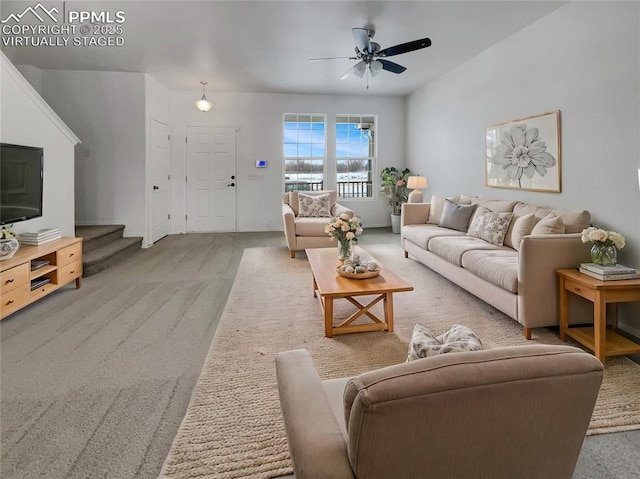 carpeted living room with stairway and a ceiling fan