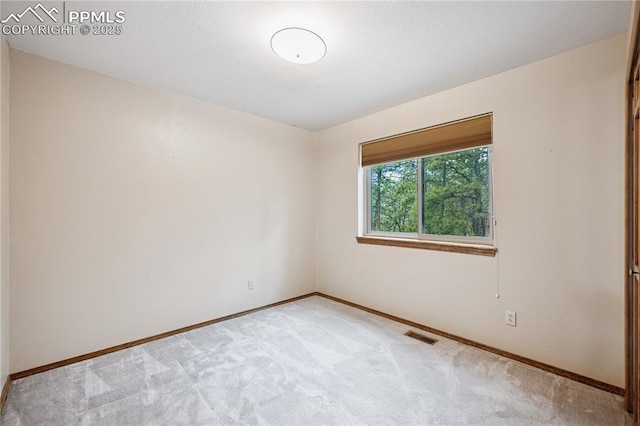 unfurnished room with baseboards and light colored carpet