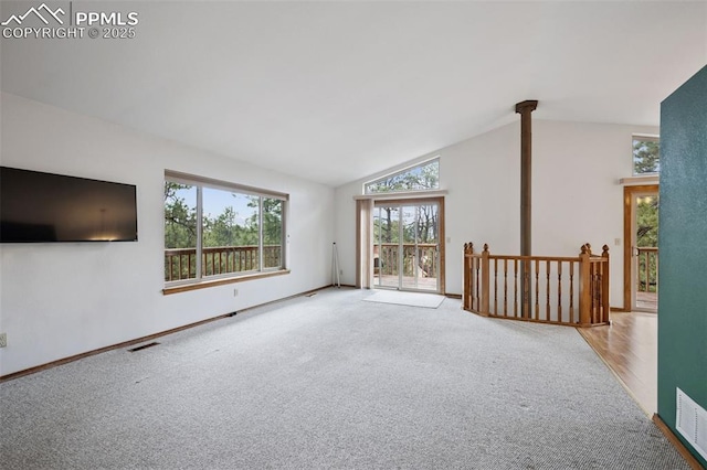 unfurnished living room featuring baseboards, visible vents, vaulted ceiling, and carpet flooring